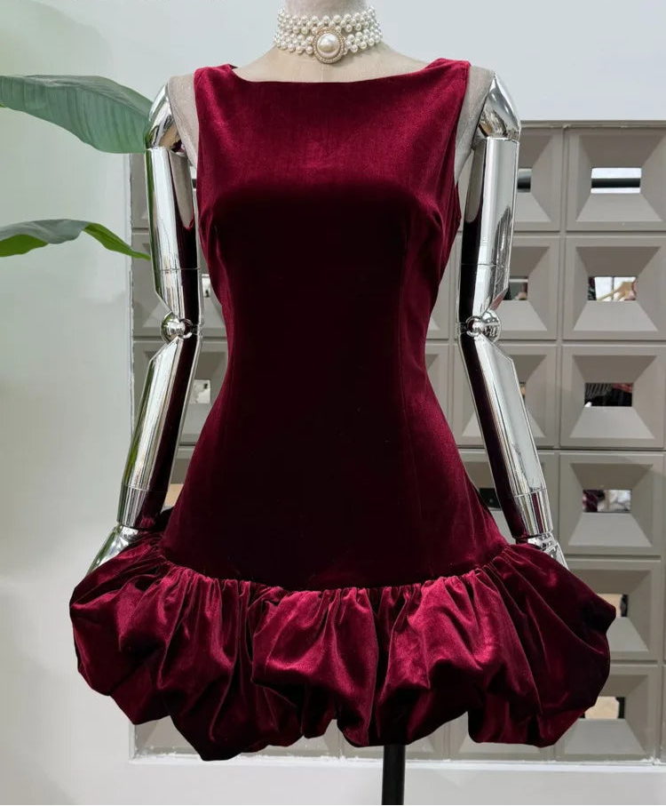 Close view of the sleeveless neckline and fitted velvet bodice on a wine-toned mini dress displayed on a mannequin.