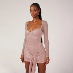 Woman wearing a pink lace dress against a plain background