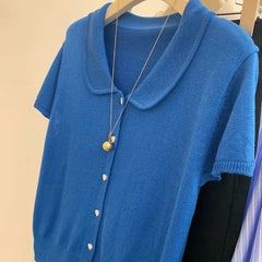 Blue cardigan with a necklace on a beige background