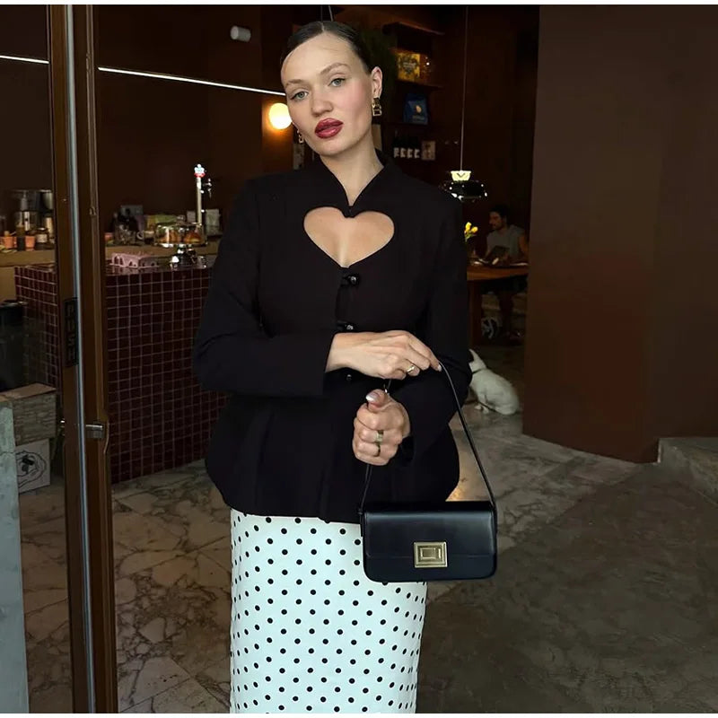 Close view of the black blazer showing the heart-shaped chest cutout and sculpted button-front tailoring for a clean, structured finish.