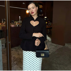 Close view of the black blazer showing the heart-shaped chest cutout and sculpted button-front tailoring for a clean, structured finish.