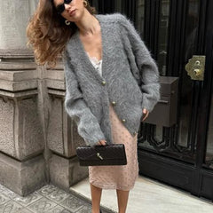 Close-up view of the gray fluffy knit highlighting the button front, soft texture, and V-neckline finish with clean stitching details.