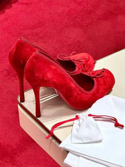 Red high-heeled shoes with a bow on a red background