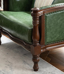 close-up of carved wood armrest and green cowhide upholstery
