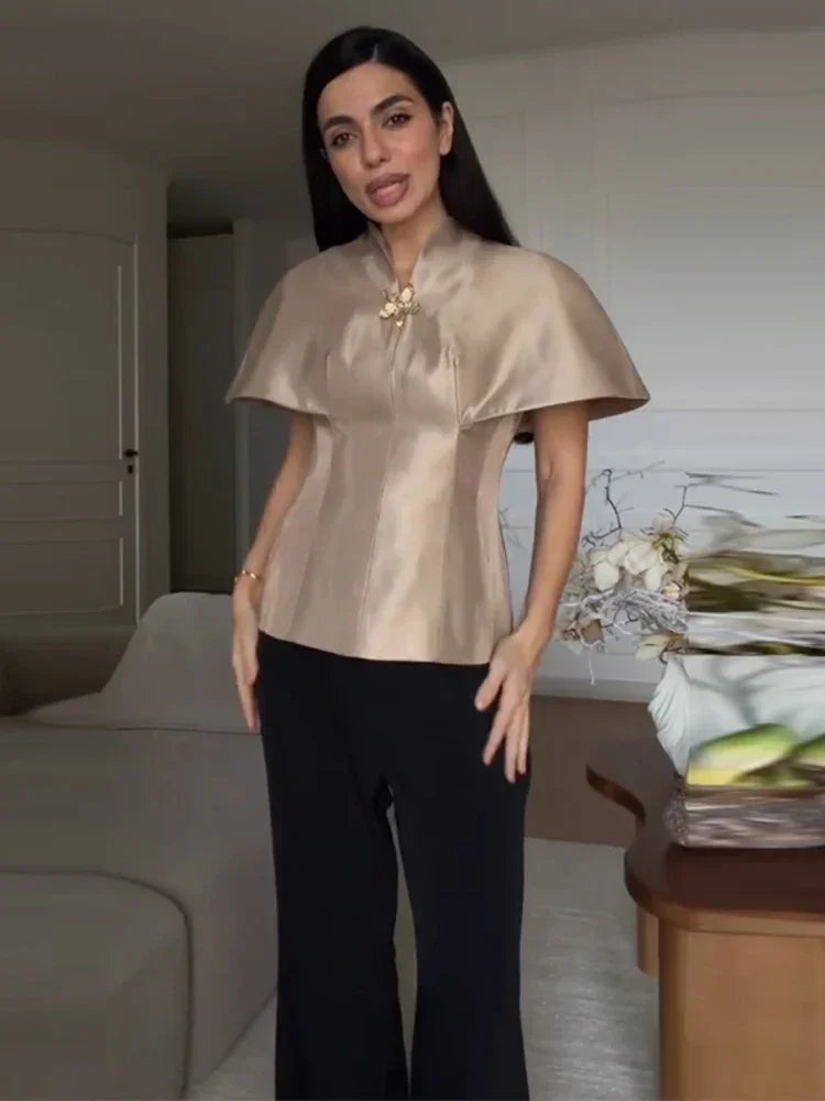 Cape-sleeve top with a cinched waist and smooth structured finish