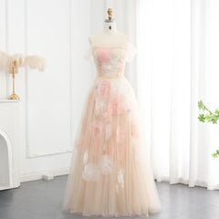 A close-up of the delicate floral appliqués and ruffles on the champagne tulle fabric.