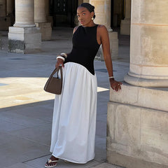Woman in elegant two-tone A-line dress for vacation or city wear, standing in front of classical architecture