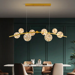 Clear glass ball LED chandelier in gold above the dining table