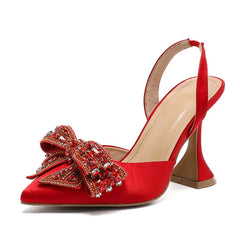 “Close-up of sequin bowknot and satin finish on red pump”

