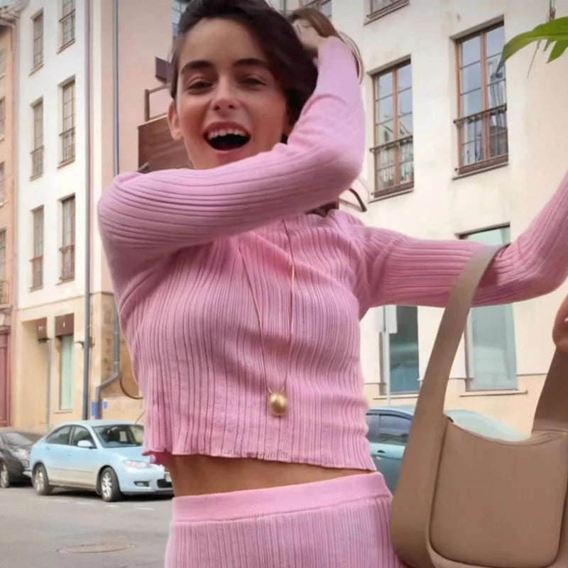 Close-up view of ribbed pink knit fabric on long sleeve sweater