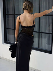 A woman wearing a club night sheer black lace maxi dress is shown for upscale events, standing by a window.