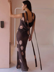 Woman wearing a dark brown dress with cut-out design, standing against a neutral background.