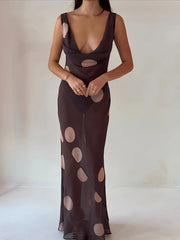 Woman wearing a brown dress with cut-out design on a plain background