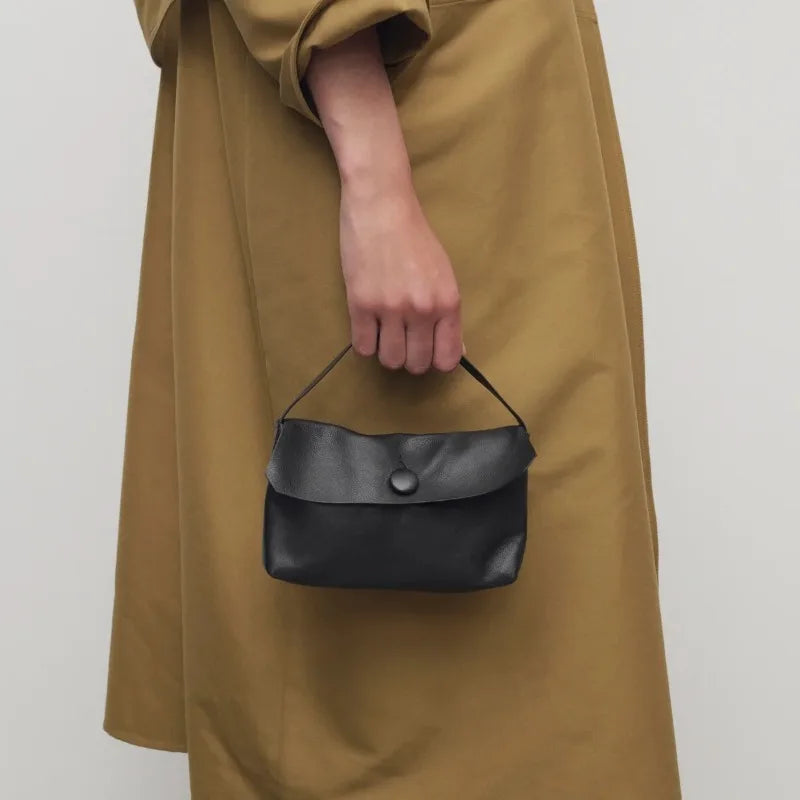 compact square handbag with fold-over flap and minimal detailing
