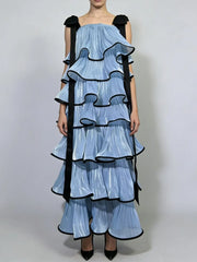 Full length editorial pose showing structured multi layer ruffles, square neck bodice and bow accent paired with pointed heels