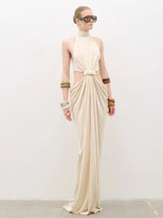 Full-length studio view of a cream sleeveless maxi dress with high round neckline, twist-knot front and soft draped skirt.
