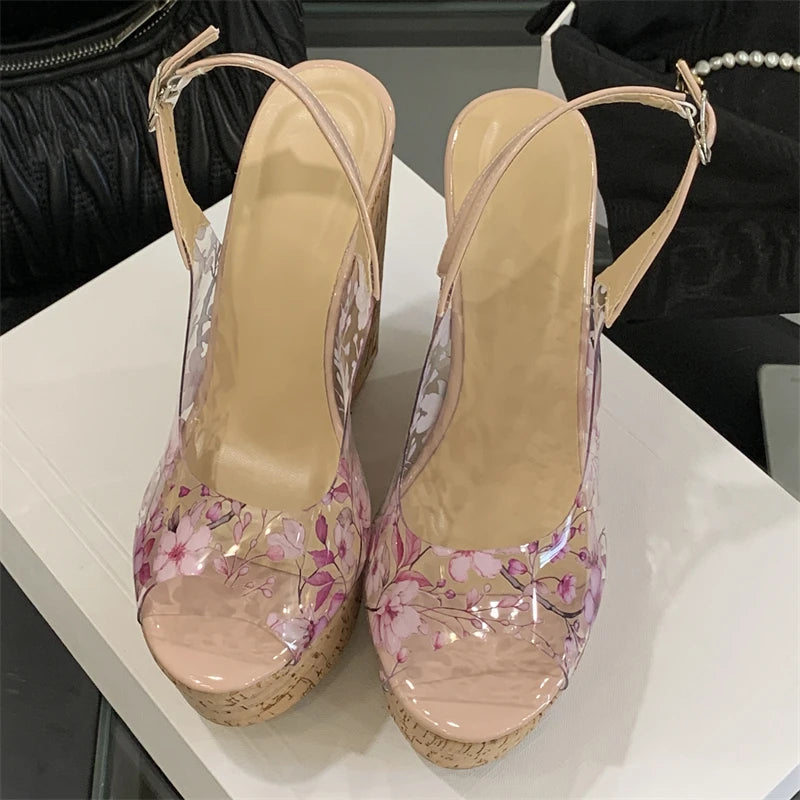 Pair of high-heeled shoes with floral design on a white surface