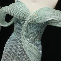 Close-up of a light blue evening gown with sparkling details on a black background