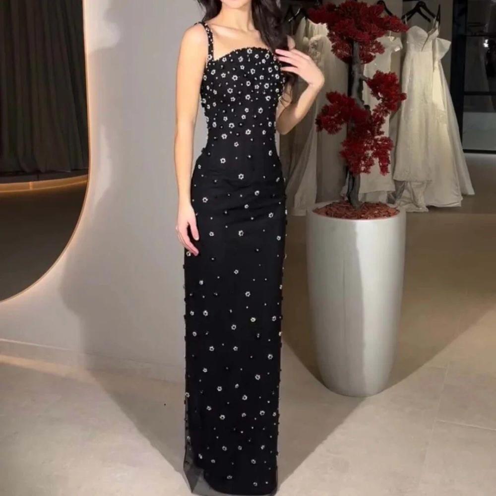Model wearing black floral crystal column gown in event setting