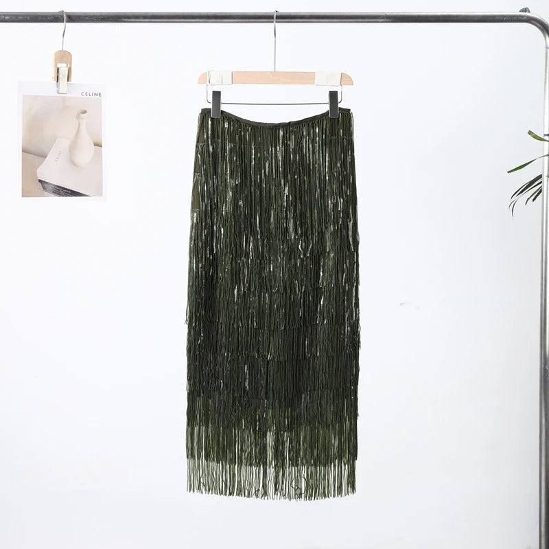 Black fringe skirt hanging on a rack against a white background