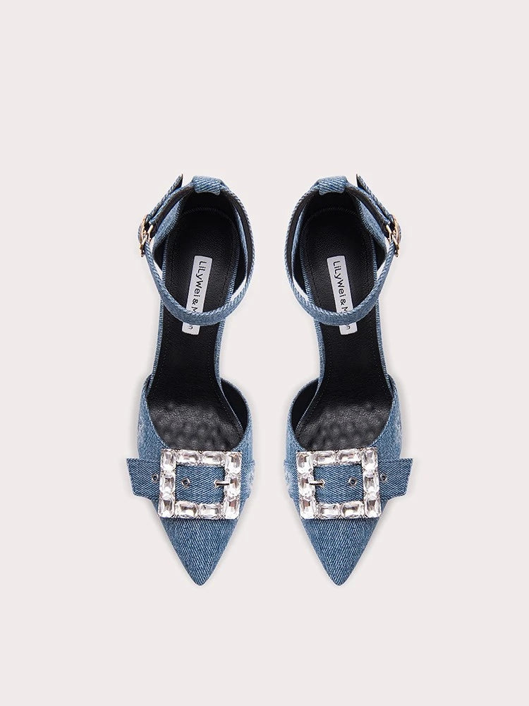 Pair of denim high heels with crystal buckles on a white background