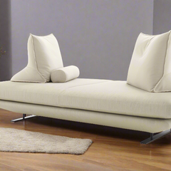 A modern, beige Prado sofa with white cushions and steel legs, displayed in a living room setting.