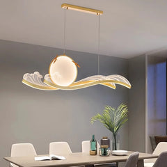 Dimmable wave pendant chandelier in gold above a dining table
