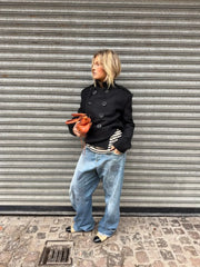 Close view of double-breasted button details on a short coat