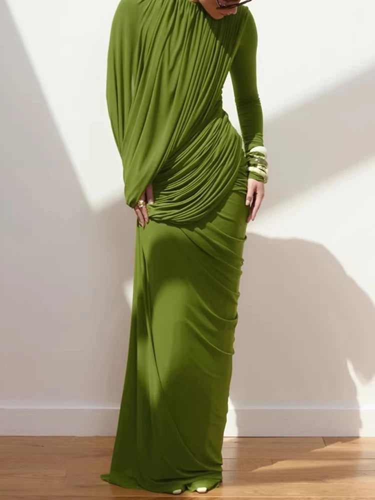 Model wearing an olive draped high neck maxi dress with long sleeves, styled with statement earrings against a clean studio backdrop.