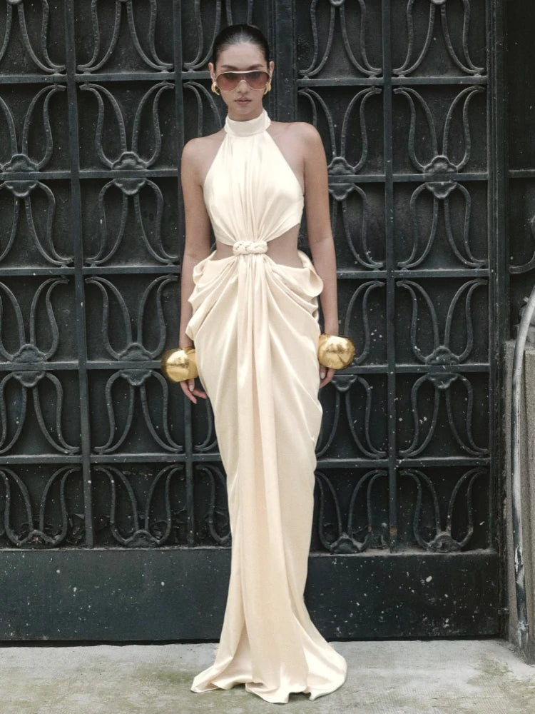 Lower-skirt detail showing the flowing drape and ankle-length hem pooling lightly, emphasizing the dress’s elongated sheath silhouette.