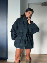 Close-up of the dark plaid fabric with the zip front and waist drawcord, highlighting the texture and adjustable shaping detail.