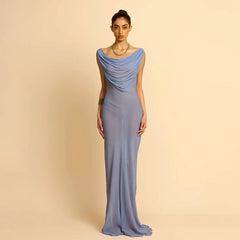 Woman wearing an Elegant banquet sheer party gown in blue with a dramatic one-shoulder silhouette on a beige background