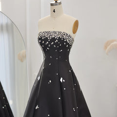 The elegant black satin dress, showing its fluid drape and timeless appeal.