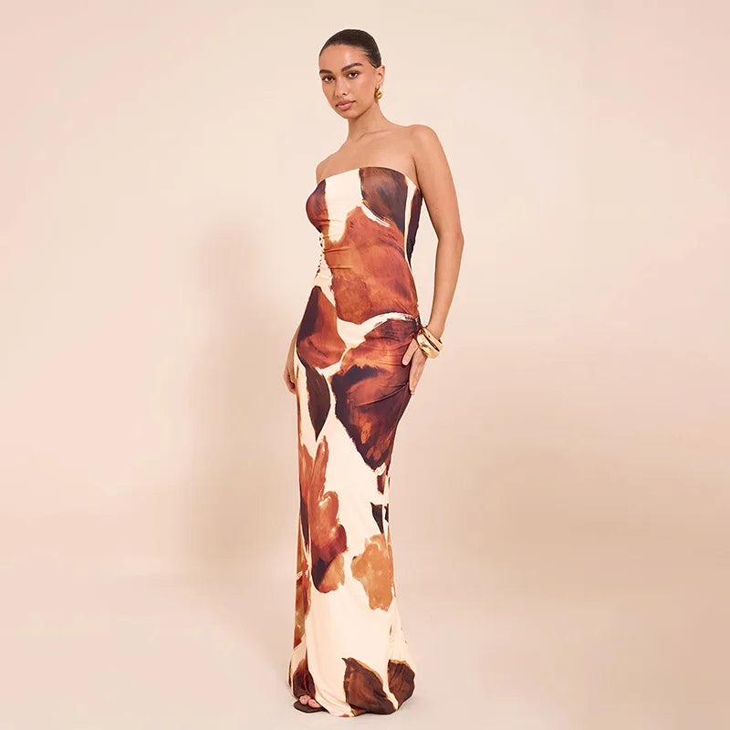 Woman wearing a full-length abstract print maxi dress styled for evening wear on a beige background