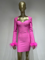 A mannequin displaying  a Pink long sleeve mini bodycon dress with feathers on the sleeves.