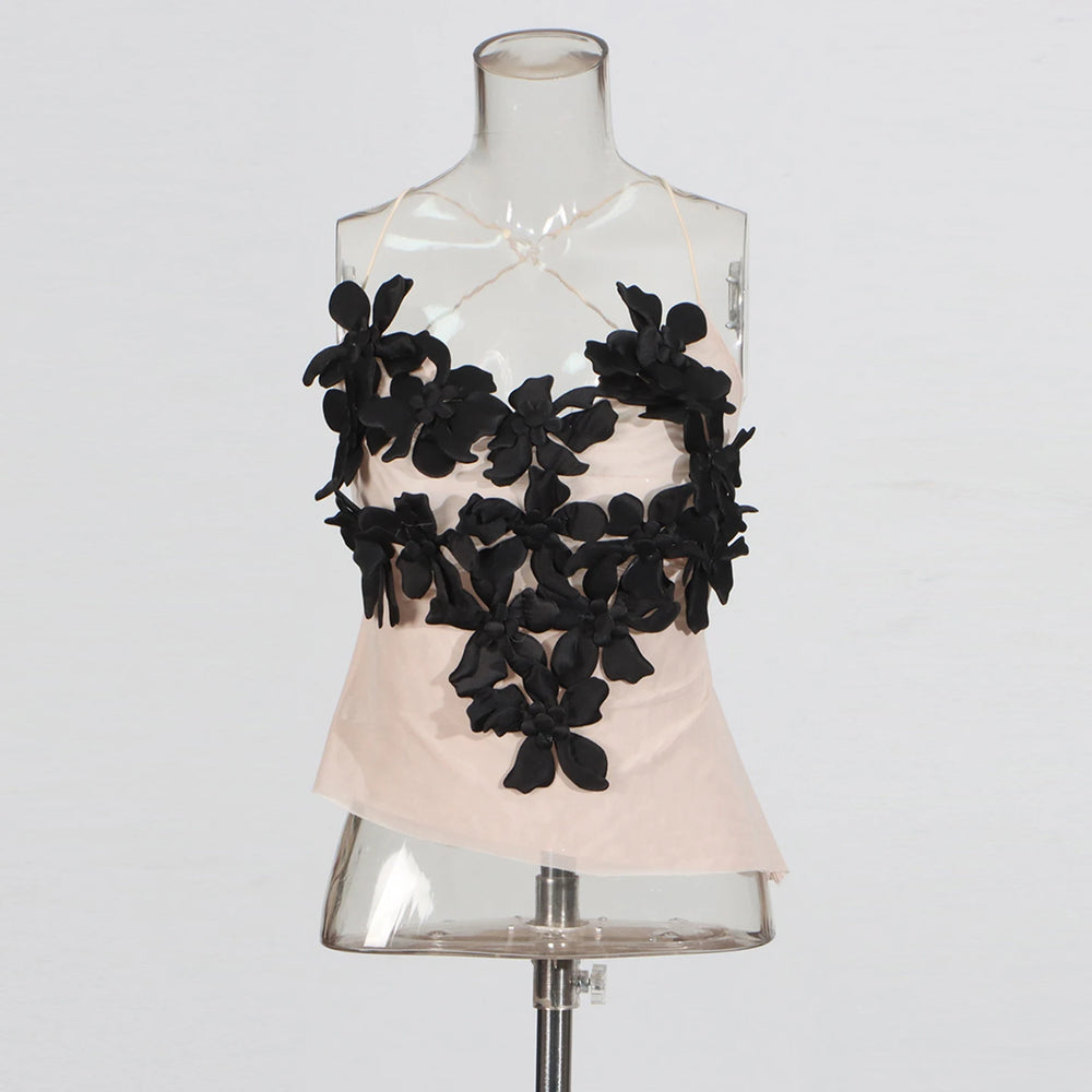 Mannequin wearing a beige top with black floral embellishments on a white background