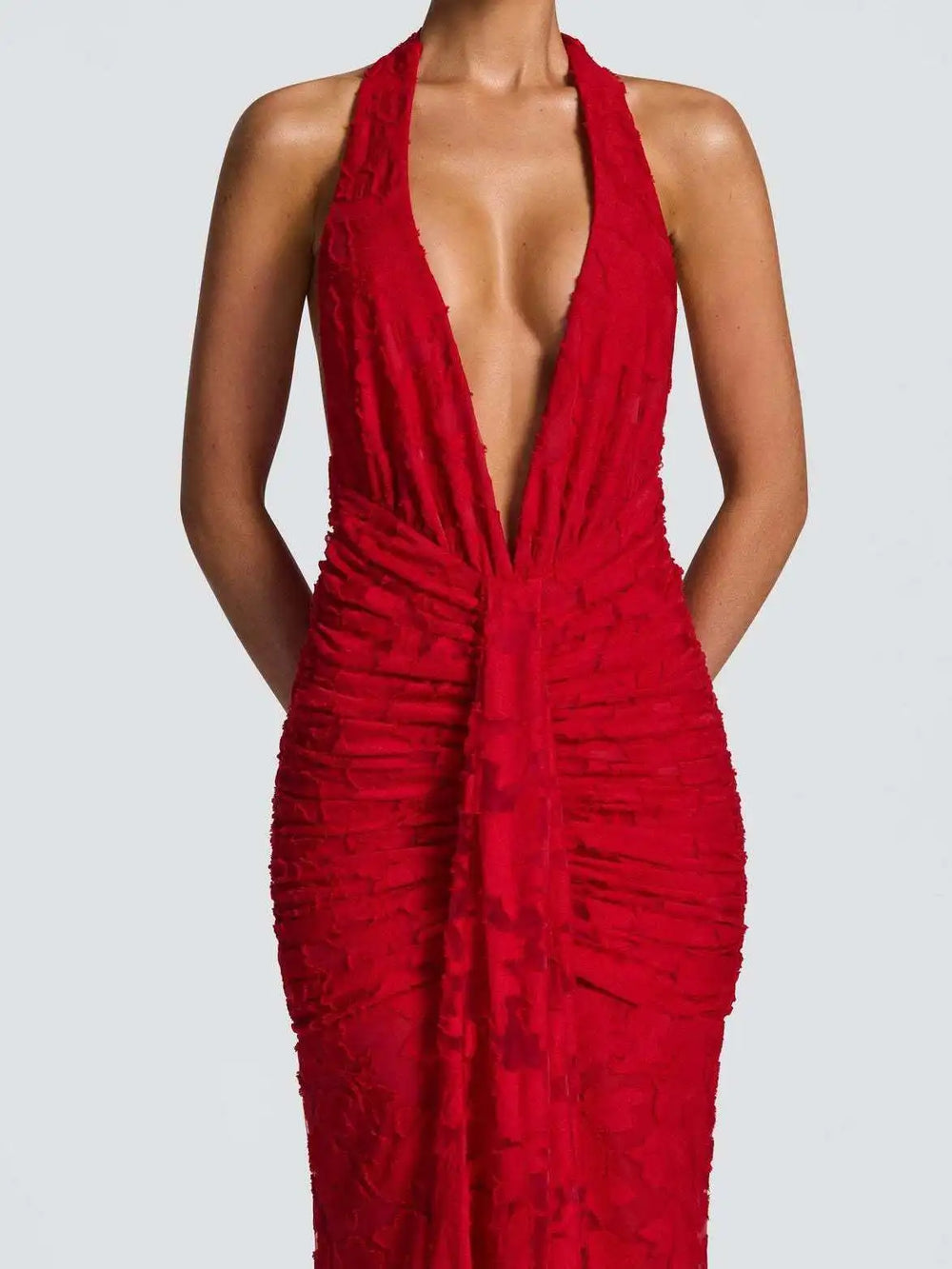 close view of deep v neckline and mesh accents on red gown
