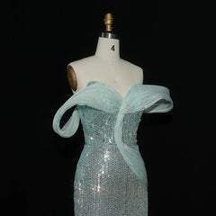 Teal sequin dress on a mannequin against a black background