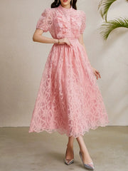 A full-length shot of a slimming ruffle dress, styled for a day at the office.