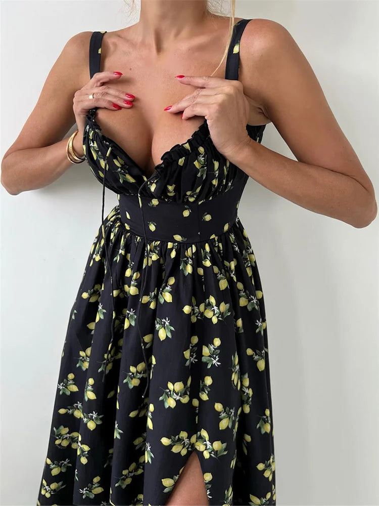 Woman wearing a black floral maxi dress styled with high heels against a white background.