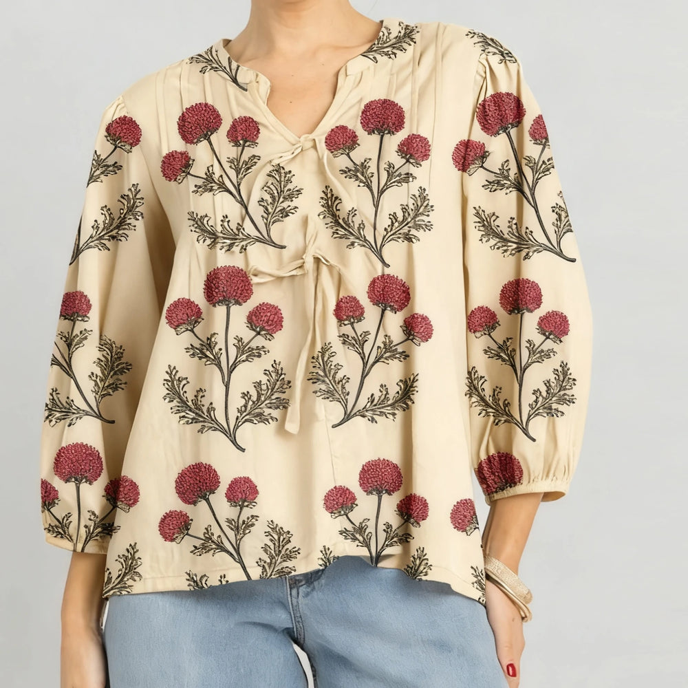 Close-up of the blouse neckline showing floral embroidery and soft tie detail.