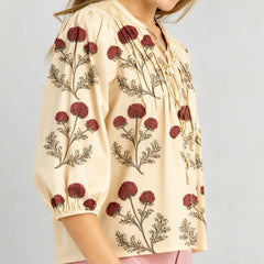 Embroidered long sleeve blouse styled casually with jeans for a relaxed daytime look.