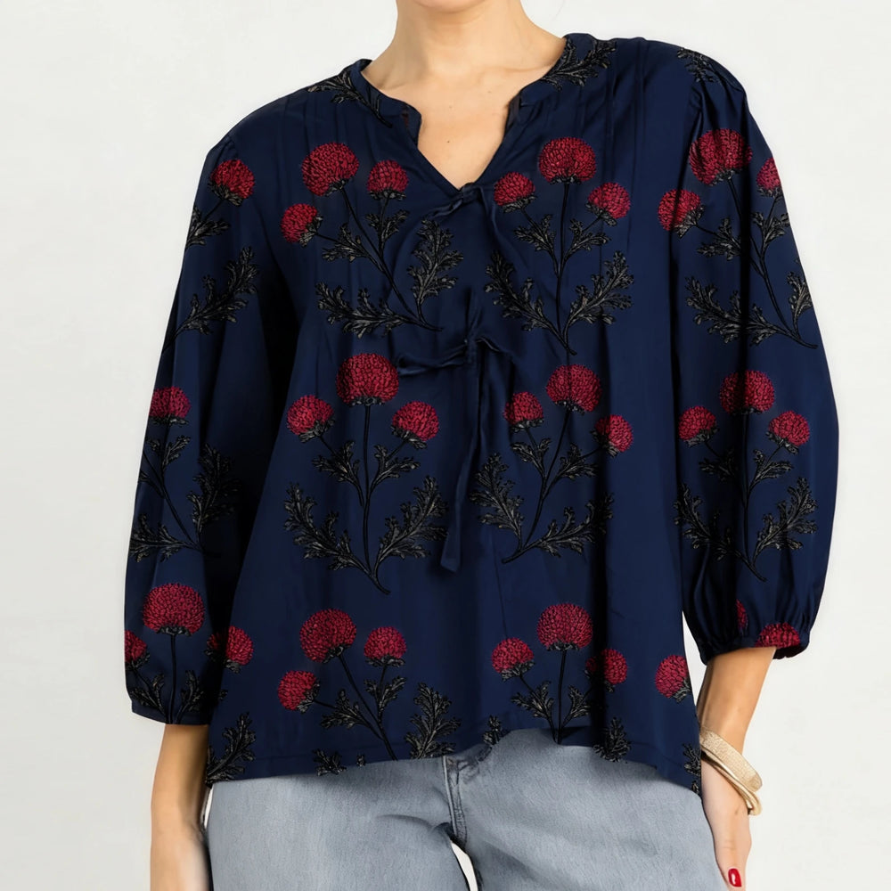 Detail view of the blouse sleeve highlighting embroidery placement and smooth fabric drape.