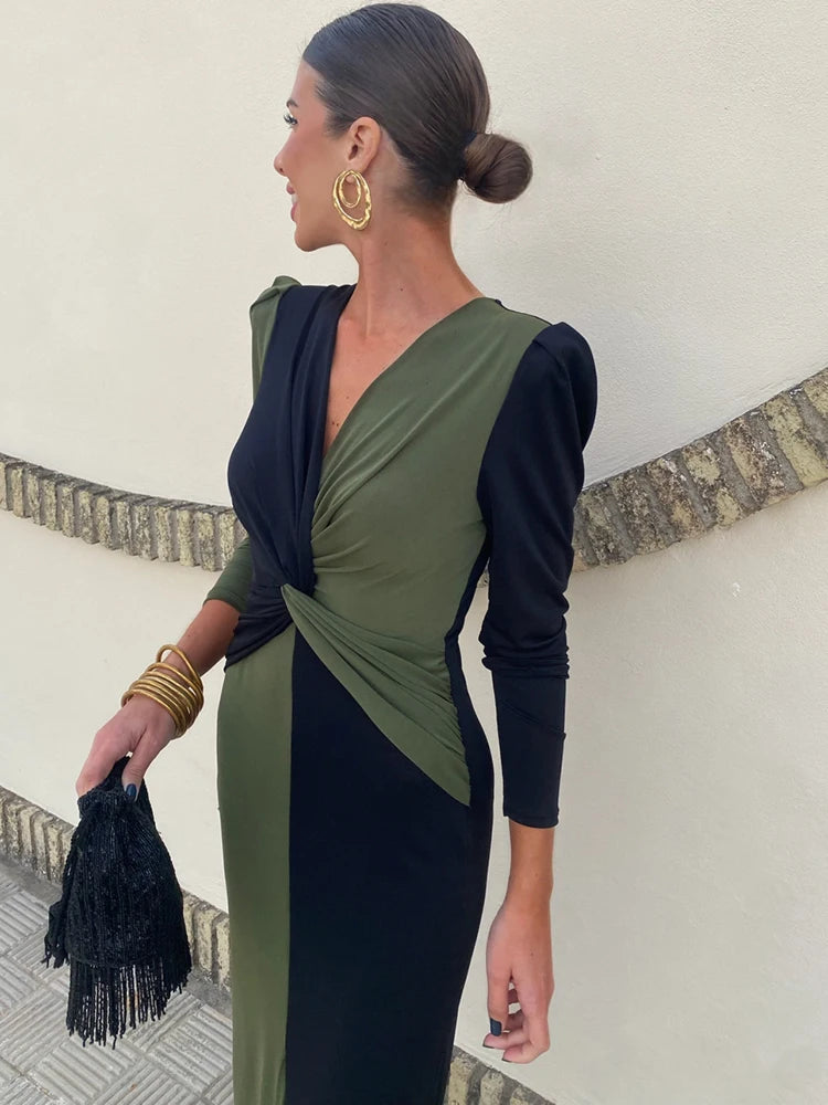 Side view of a two-tone evening maxi dress showing sculpted waist ruching and confident front slit.