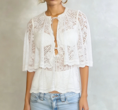 White lace cape blouse styled with denim and a bralette