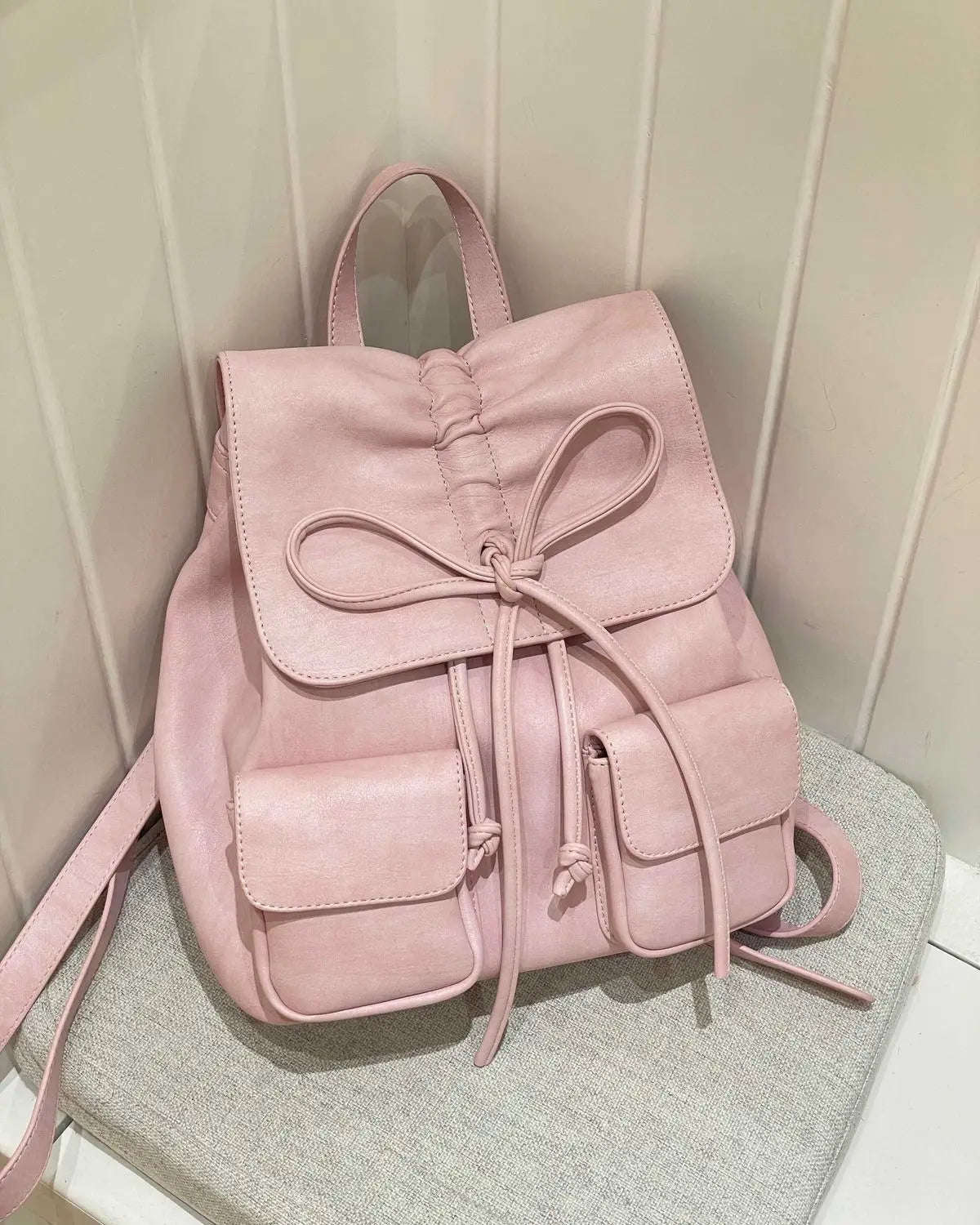 Fairycore pink bow backpack on a gray surface