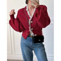 Close-up of lace neckline and vintage button details on knitted cardigan.