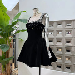 Front view highlighting the structured flared mini skirt silhouette and fitted bodice on a black embellished mini dress.