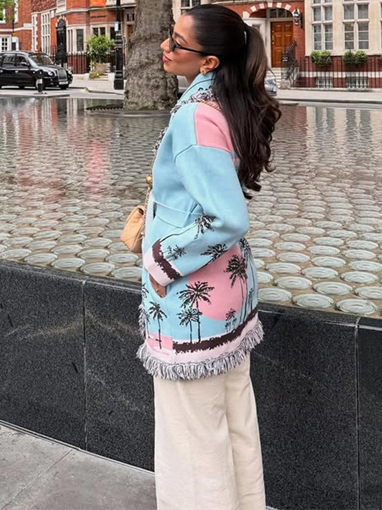 Side angle showing the flare sleeve shape and longline drape of the light blue patterned cardigan, finished with soft fringe at the hem.