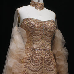 Mannequin wearing a beaded evening gown with a sheer overlay on a black background